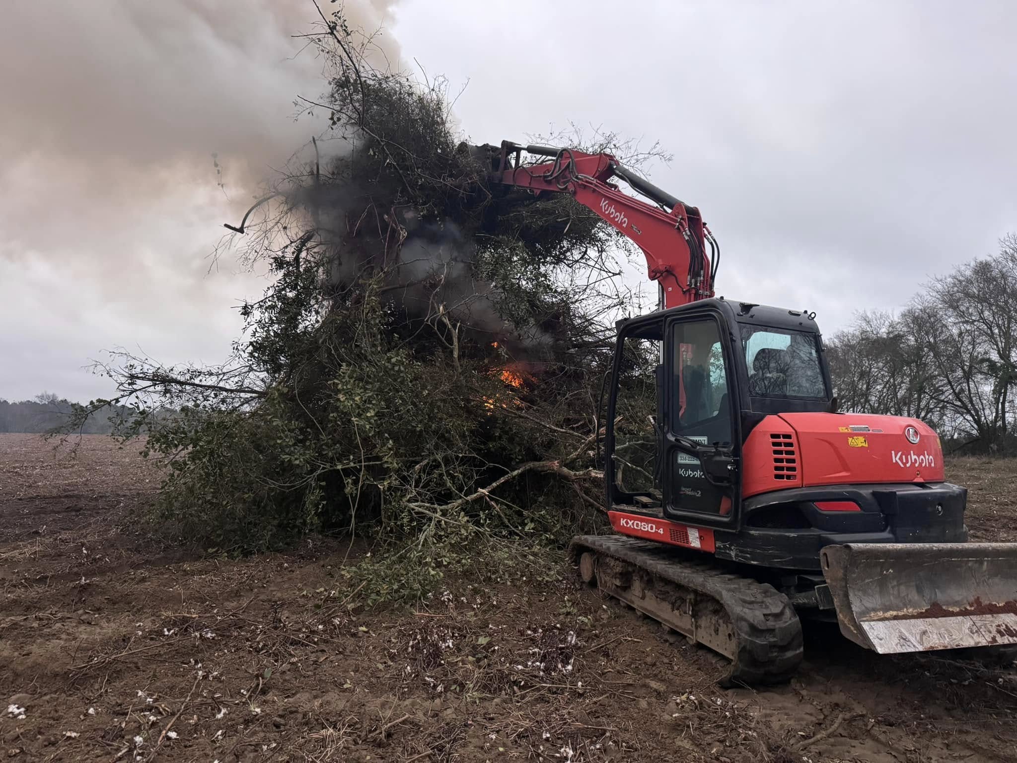Kubota excavator clearing brush with controlled burn
