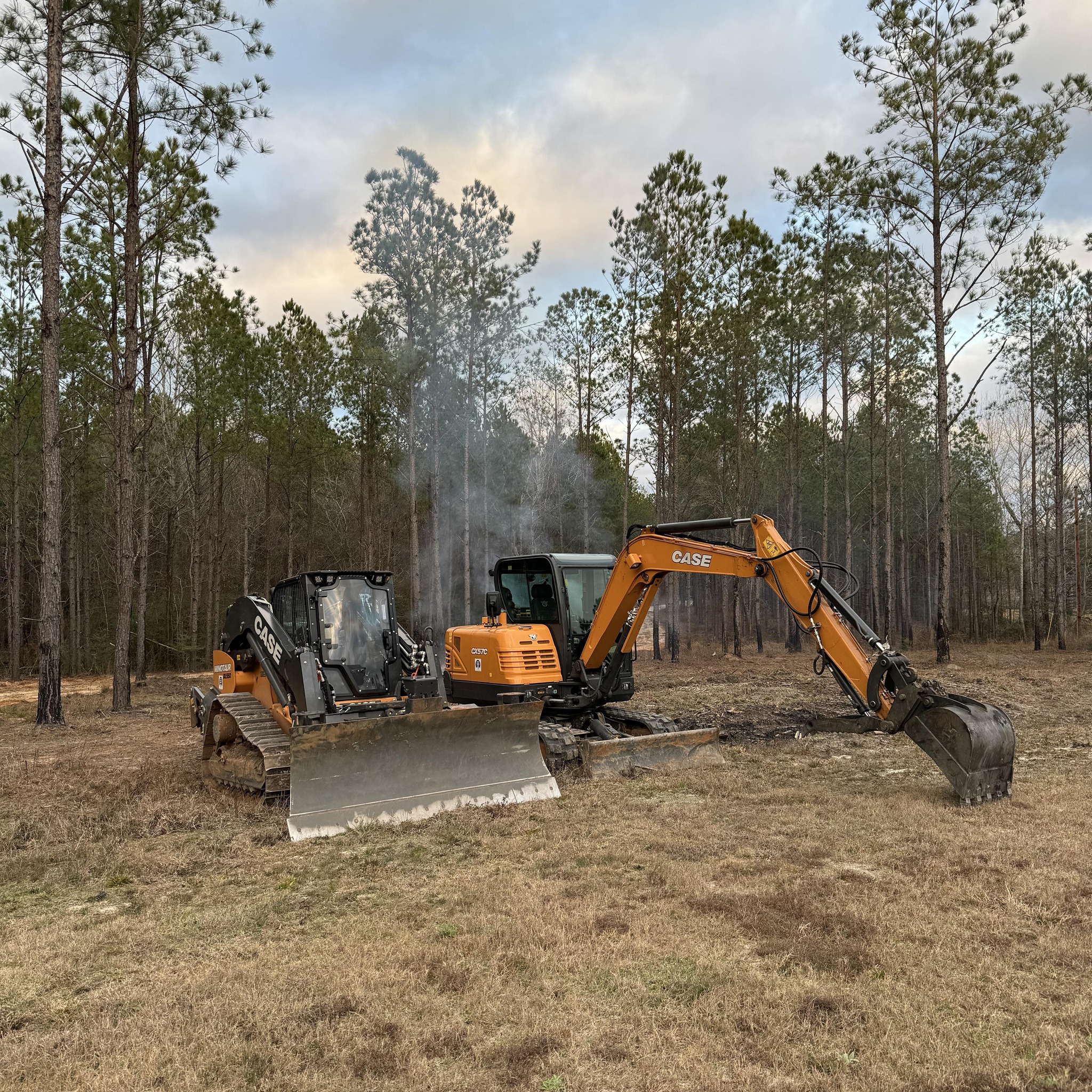 Case track loader and excavator working together