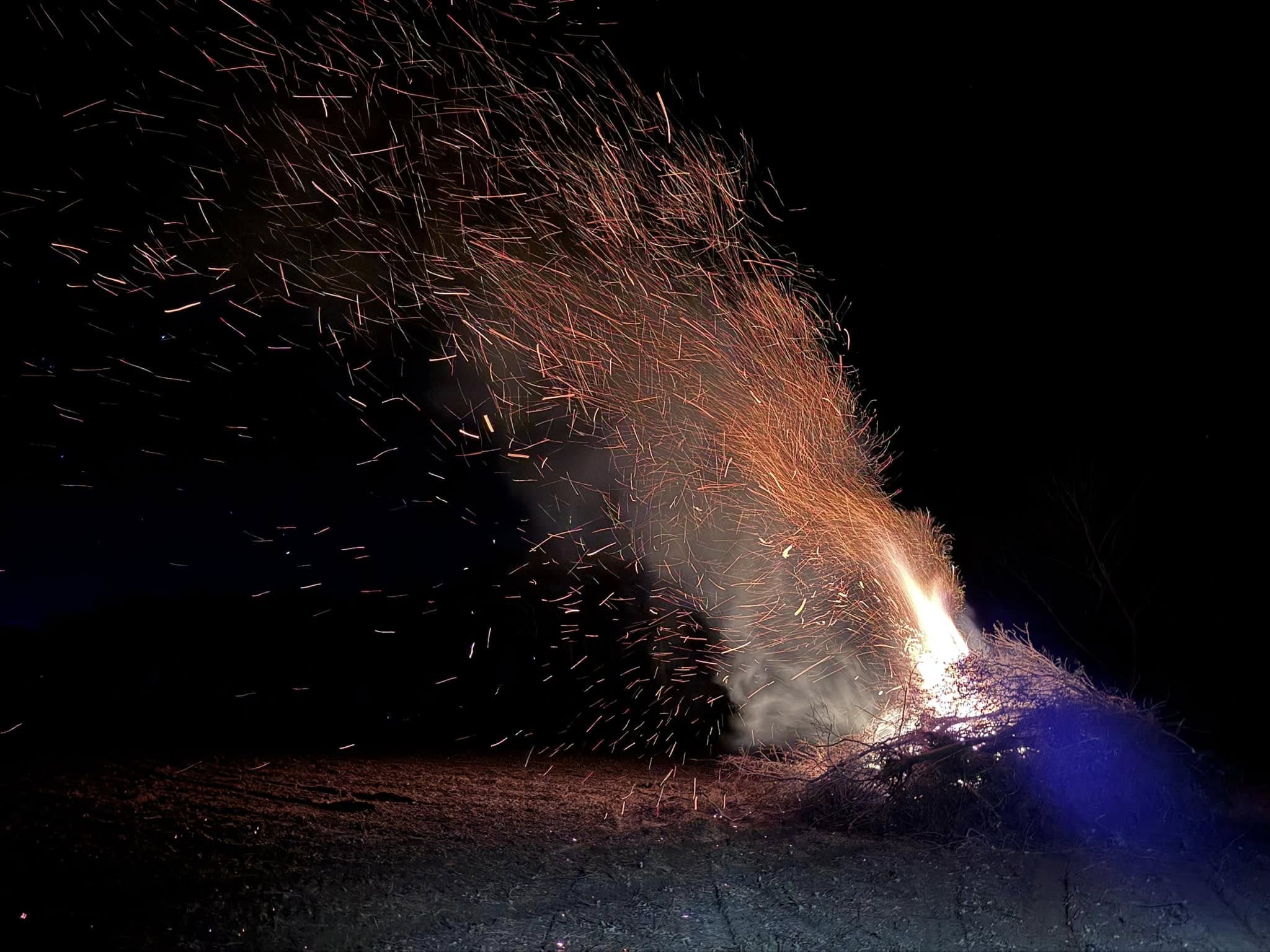 Dramatic nighttime controlled burn with sparks